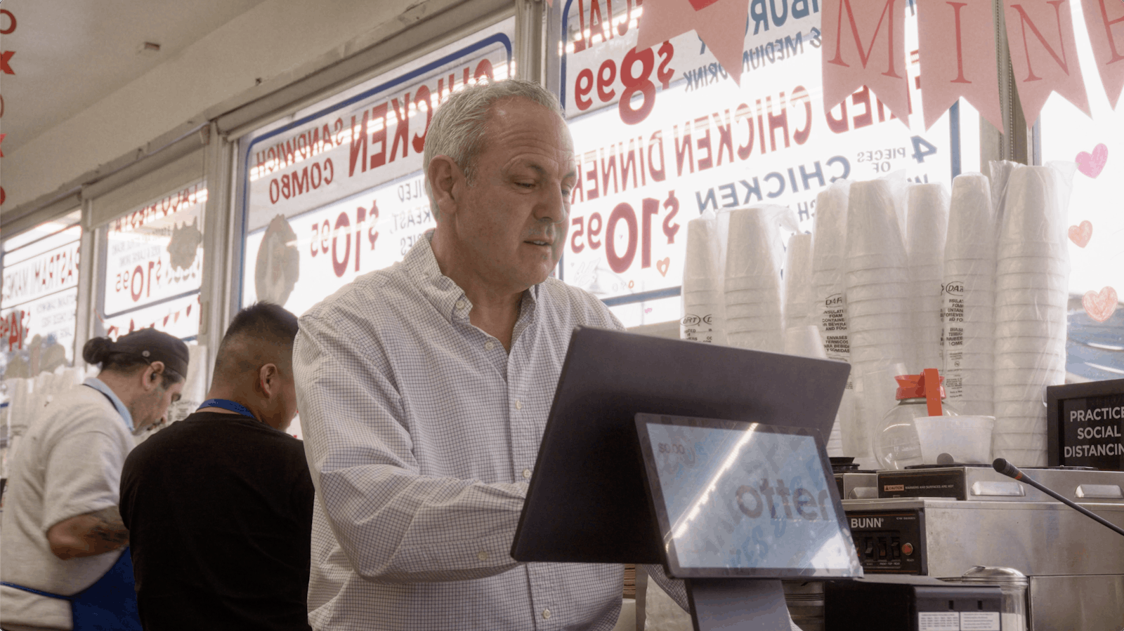 The owner of Jim's Burgers taking an order with Otter's Restaurant Operating System.
