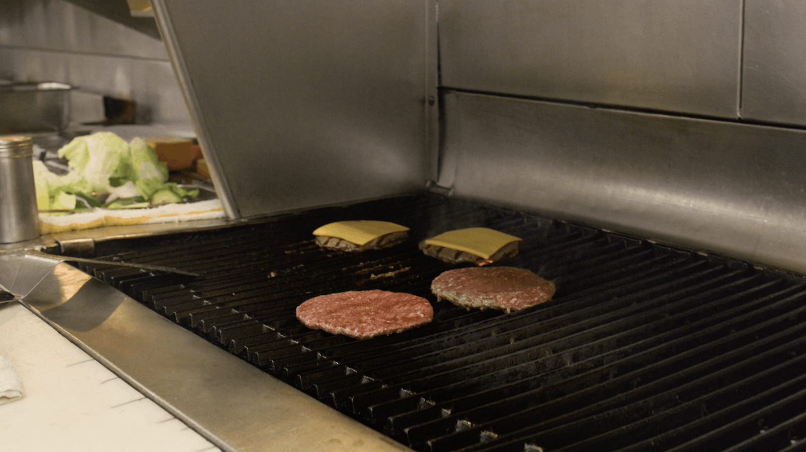 Some food being cooked at Jim's Burgers. 