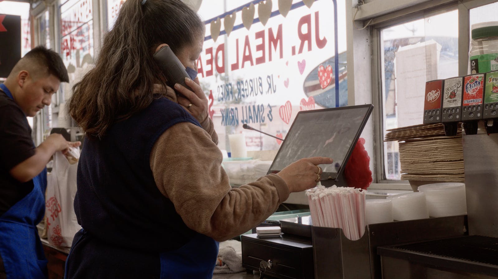 A staff member using Otter's Restaurant Operating System at Jim's Burgers.
