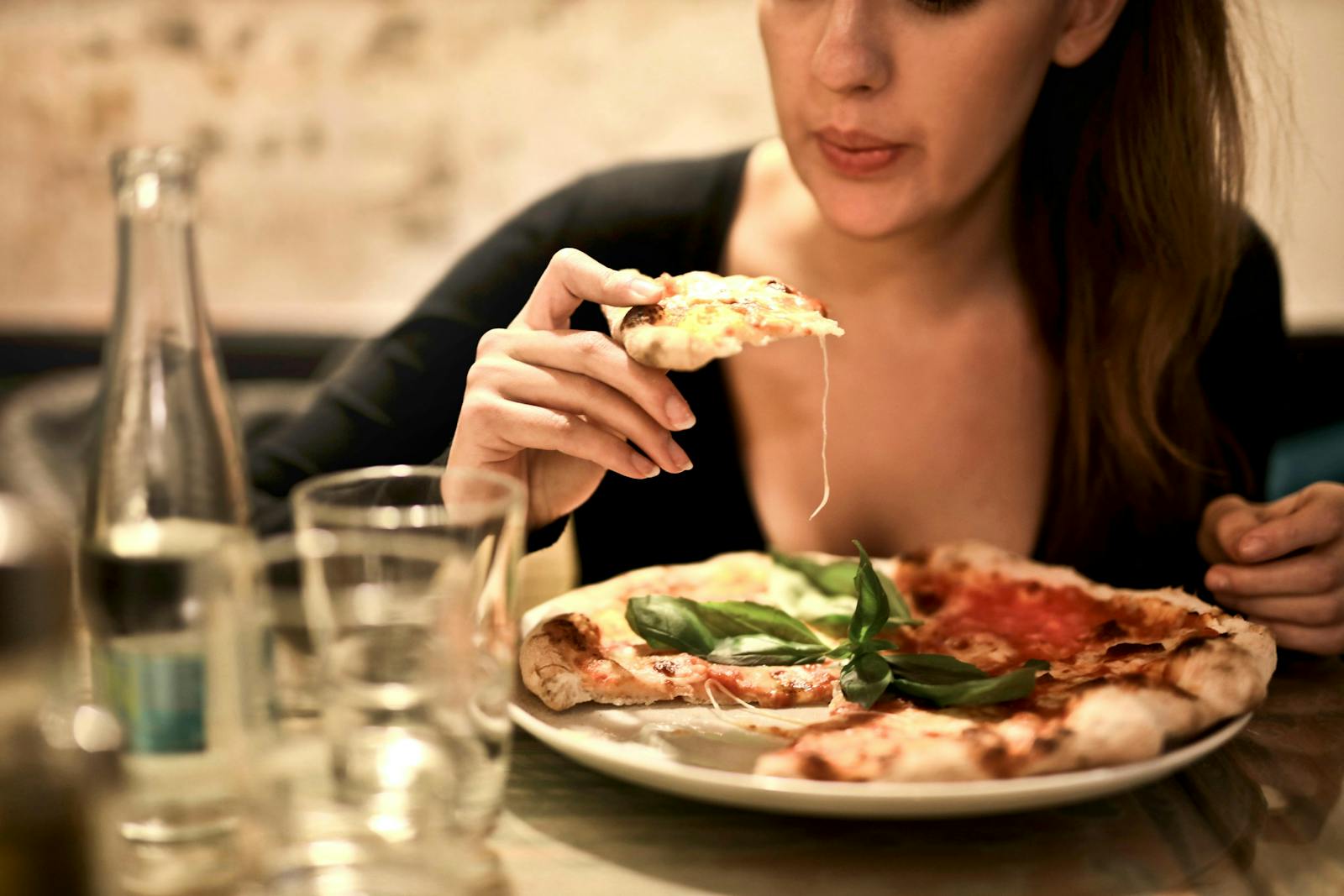 A customer eating pizza at a chain or pizzeria.