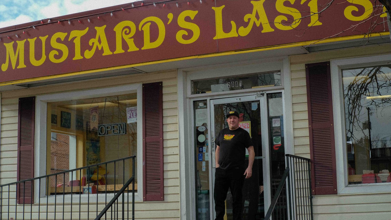 Photo of owner of Mustard's Last Stand in front of restaurant