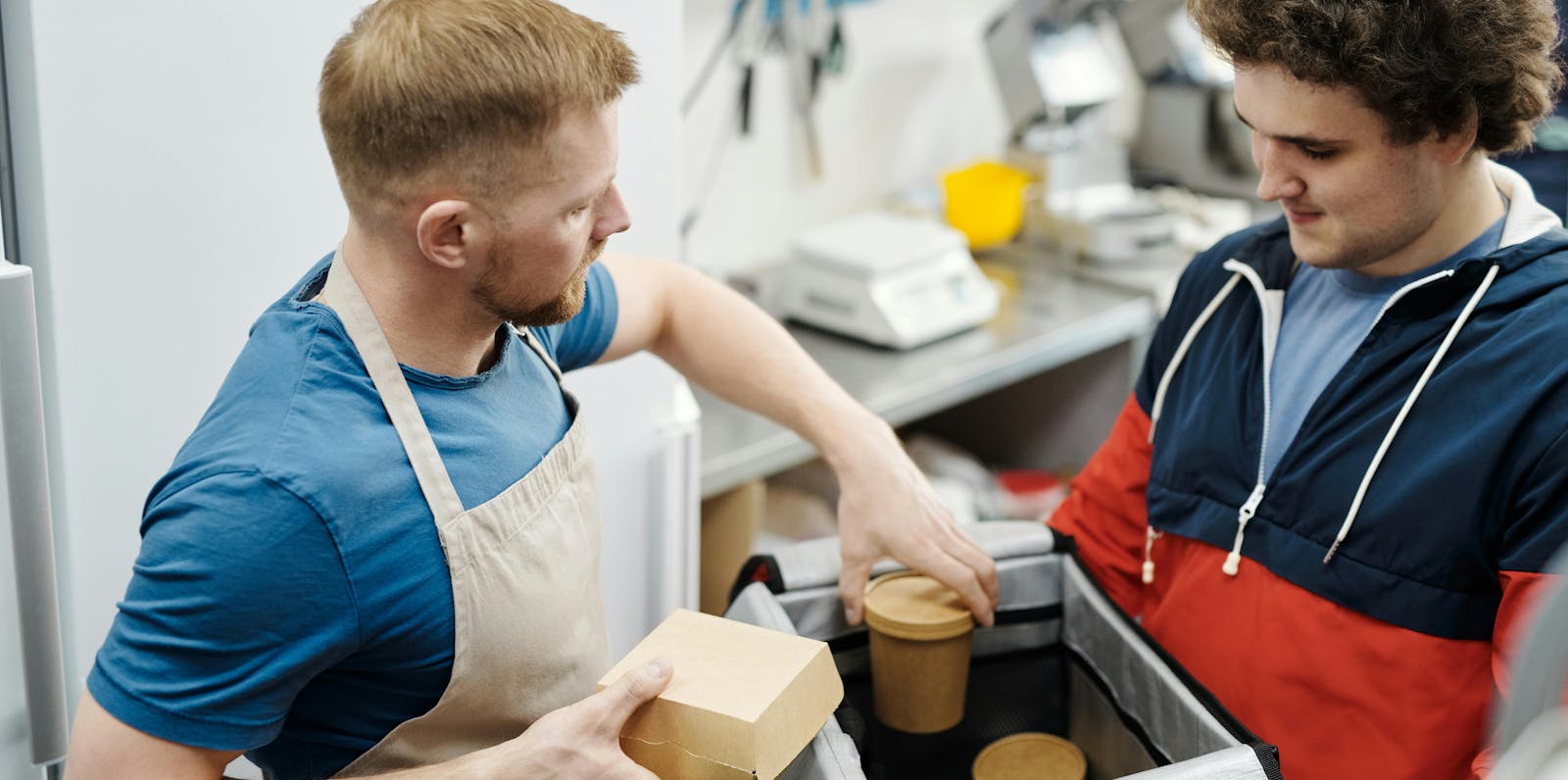 A restaurant owner loading a delivery order. 