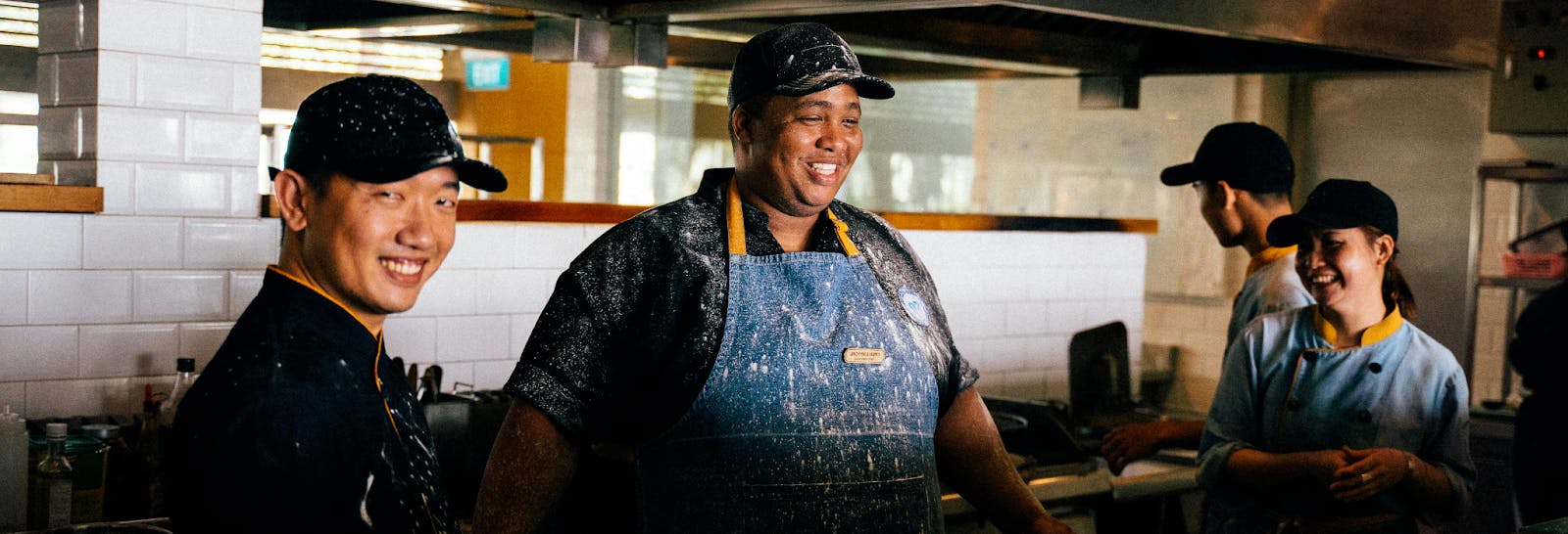 Some restaurant owners and staff working in a kitchen. 