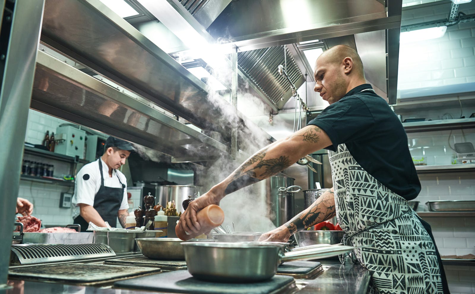 Restaurant staff cooking in a kitchen. 