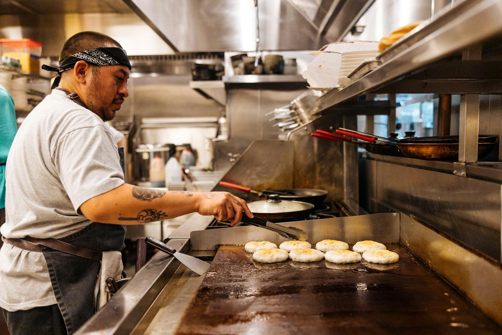 Image of a restaurant employee frying dumplings.