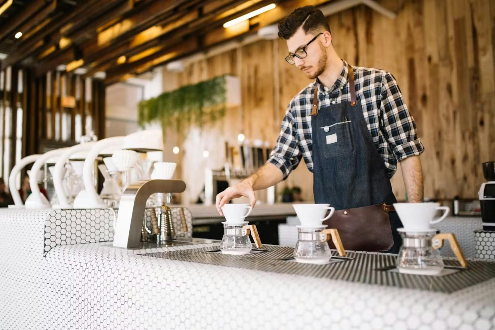 Barista pouring coffee at cafe.