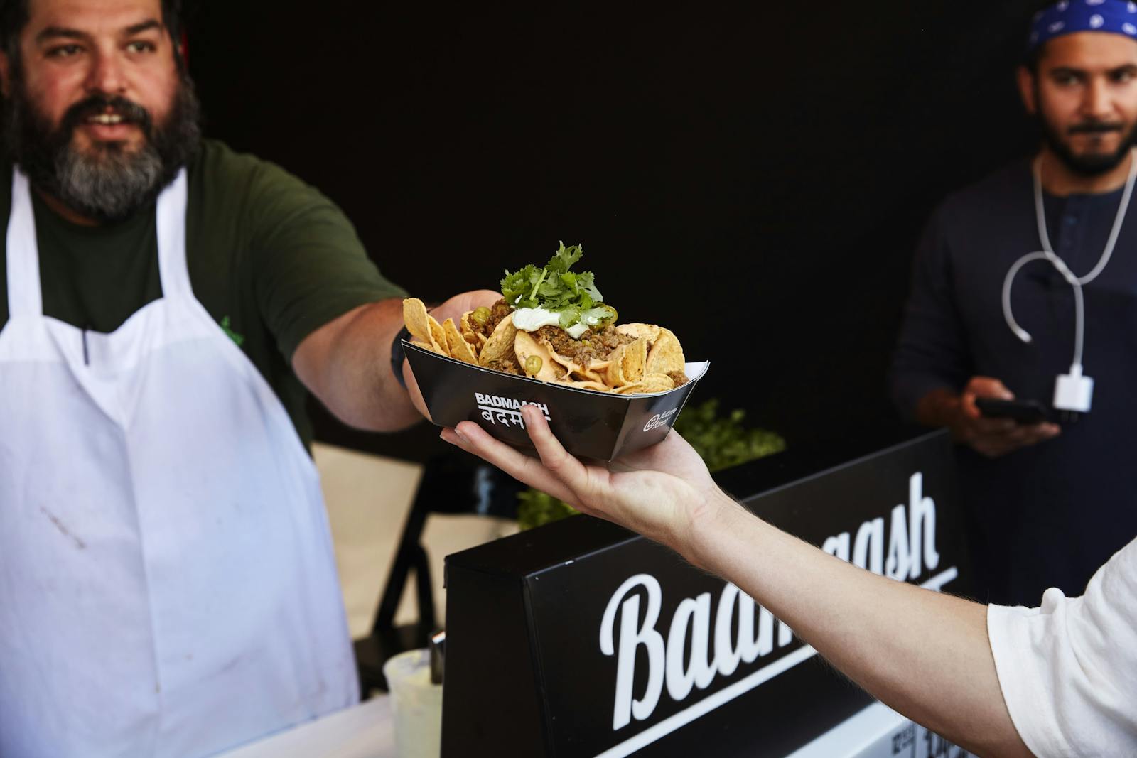 Image of restaurant employee handing off an order to a customer