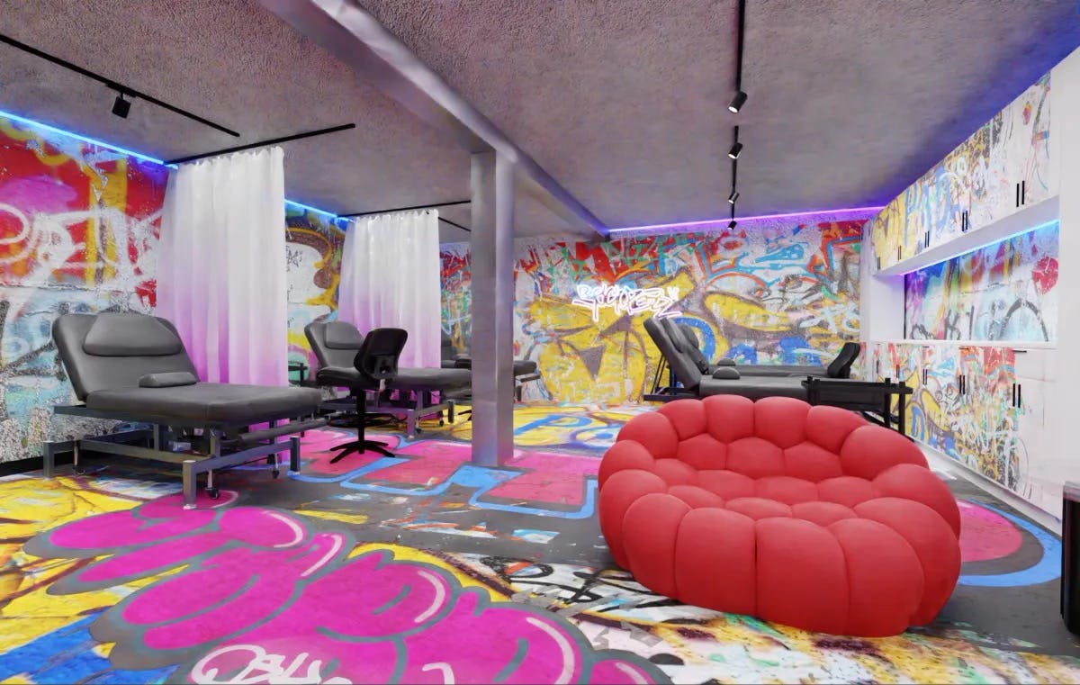 Spacious tattoo operating area with clean black stations, white walls, and pops of bold color from graffiti artwork for an energetic creative workspace.