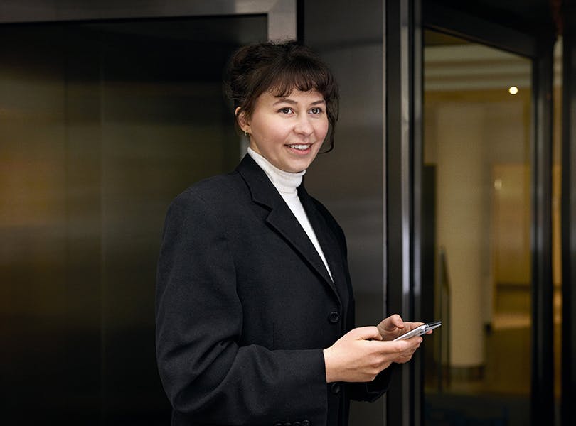 woman in blazer holding phone