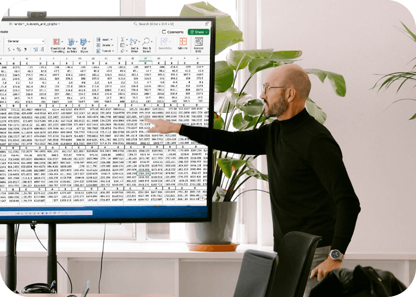 A man pointing at the screen with an Excel spreadsheet open 