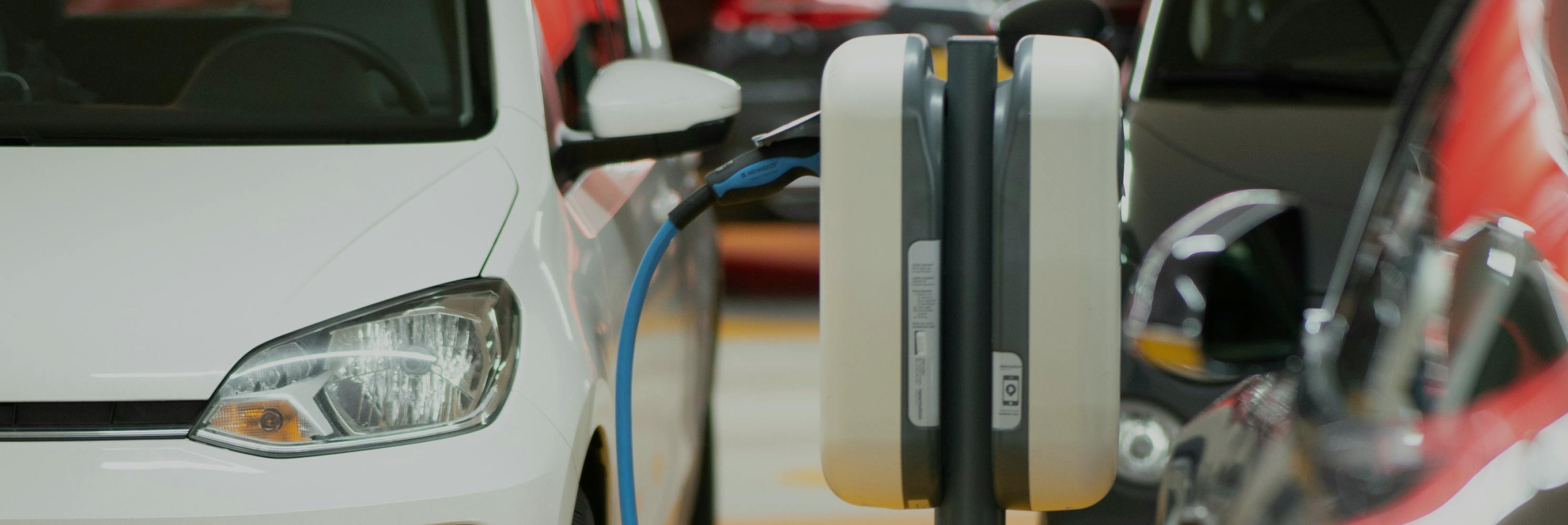 Electric vehicles charging at a public charging station in an urban setting.