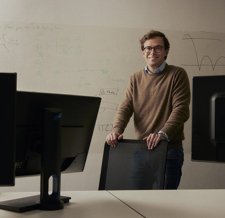 man holding onto chair infront of whiteboard