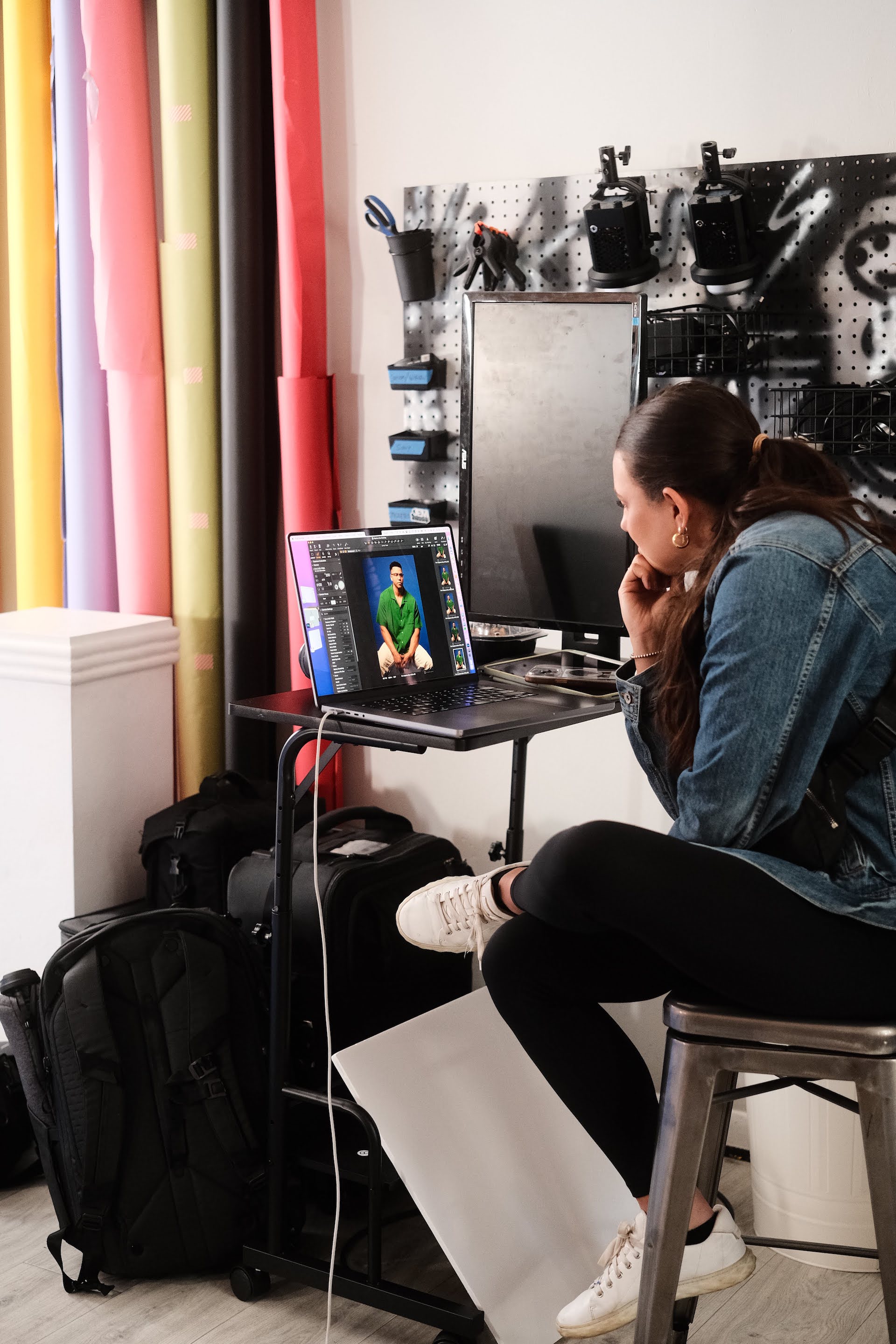 female director reviewing images at a photoshoot on a laptop