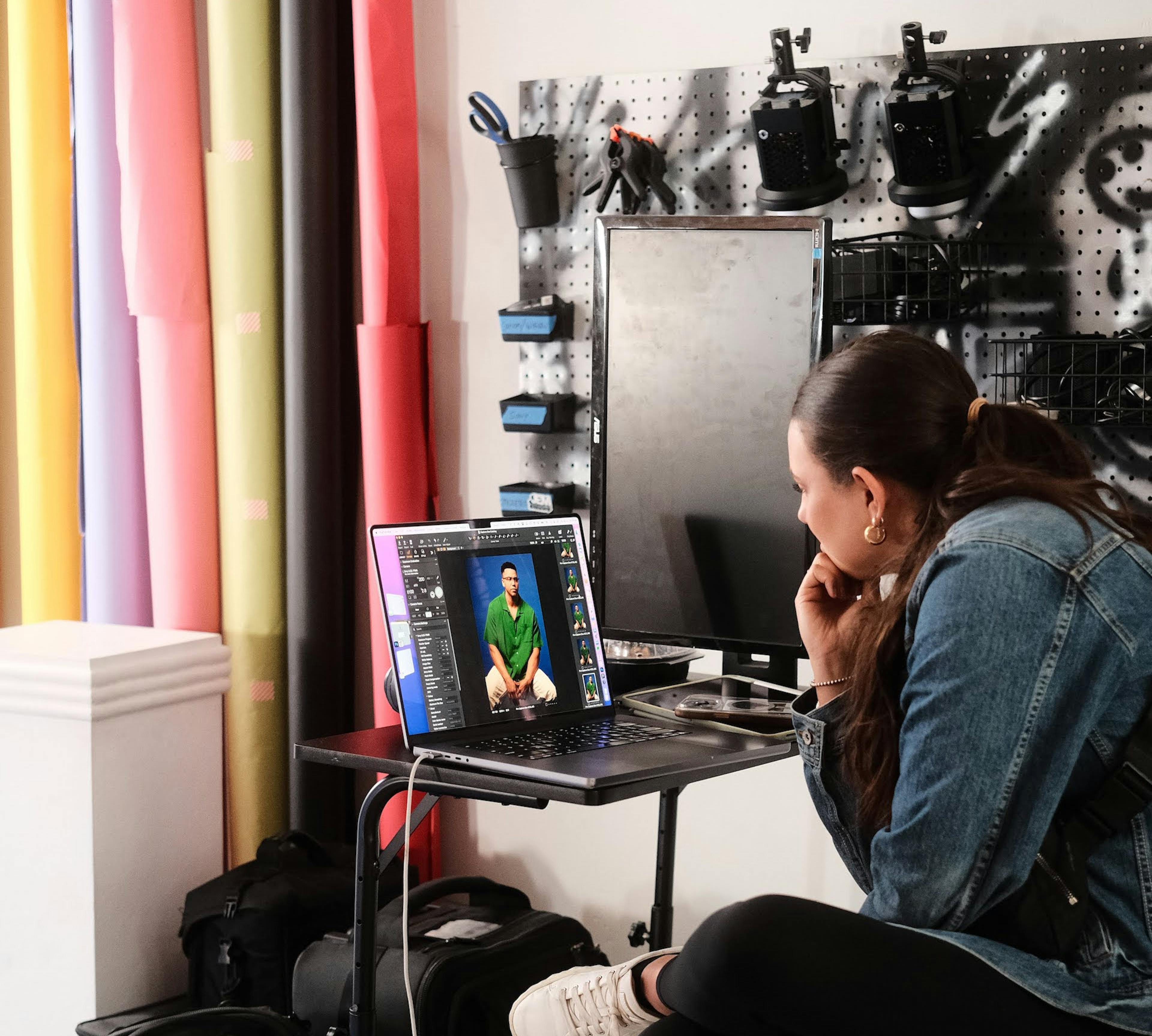 female director reviewing images at a photoshoot on a laptop