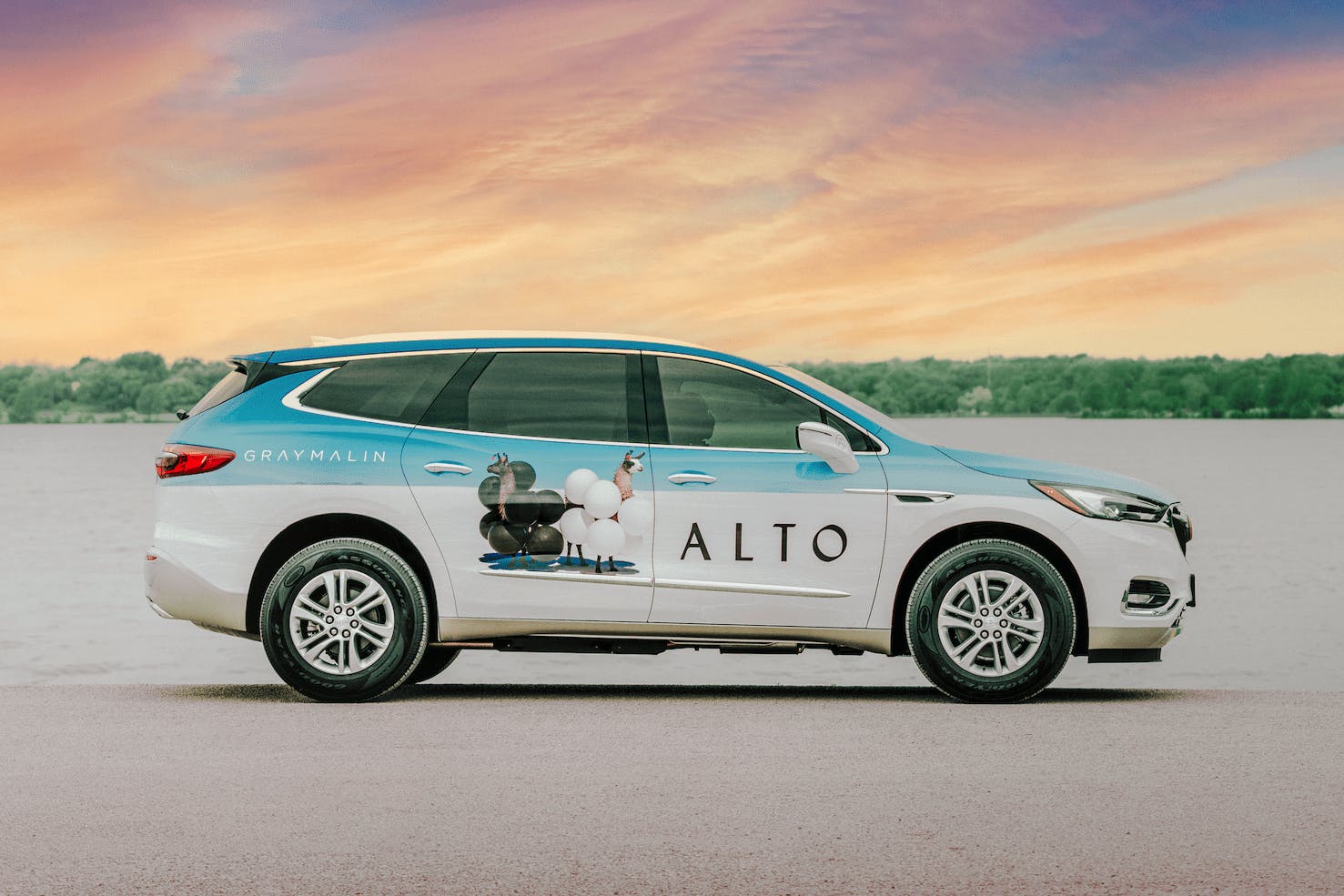 Alto Rideshare wrapped art car with Gray Malin llams in front of a sunset