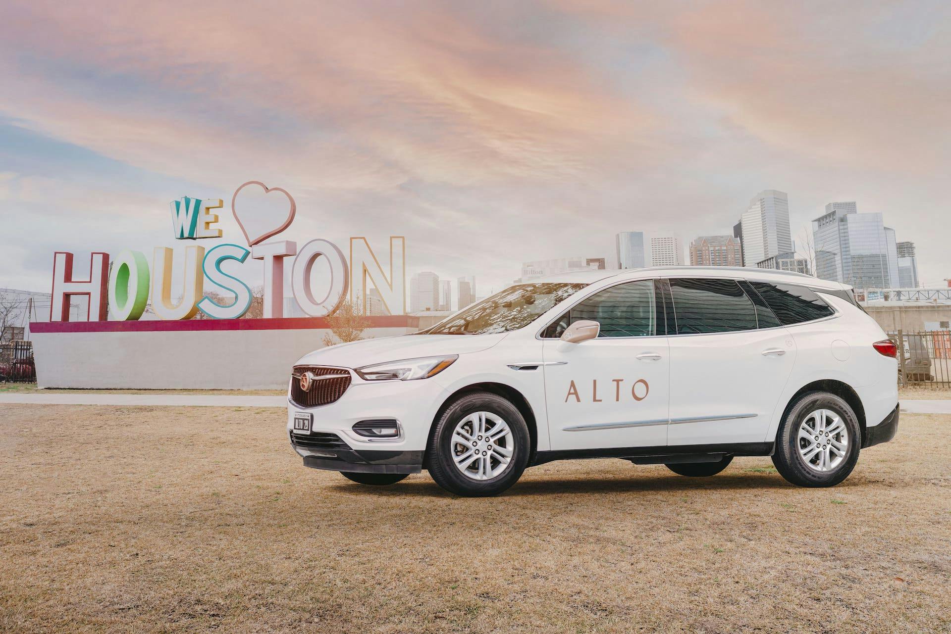 Alto ride share vehicle posed beside an "I Love Houston" sign