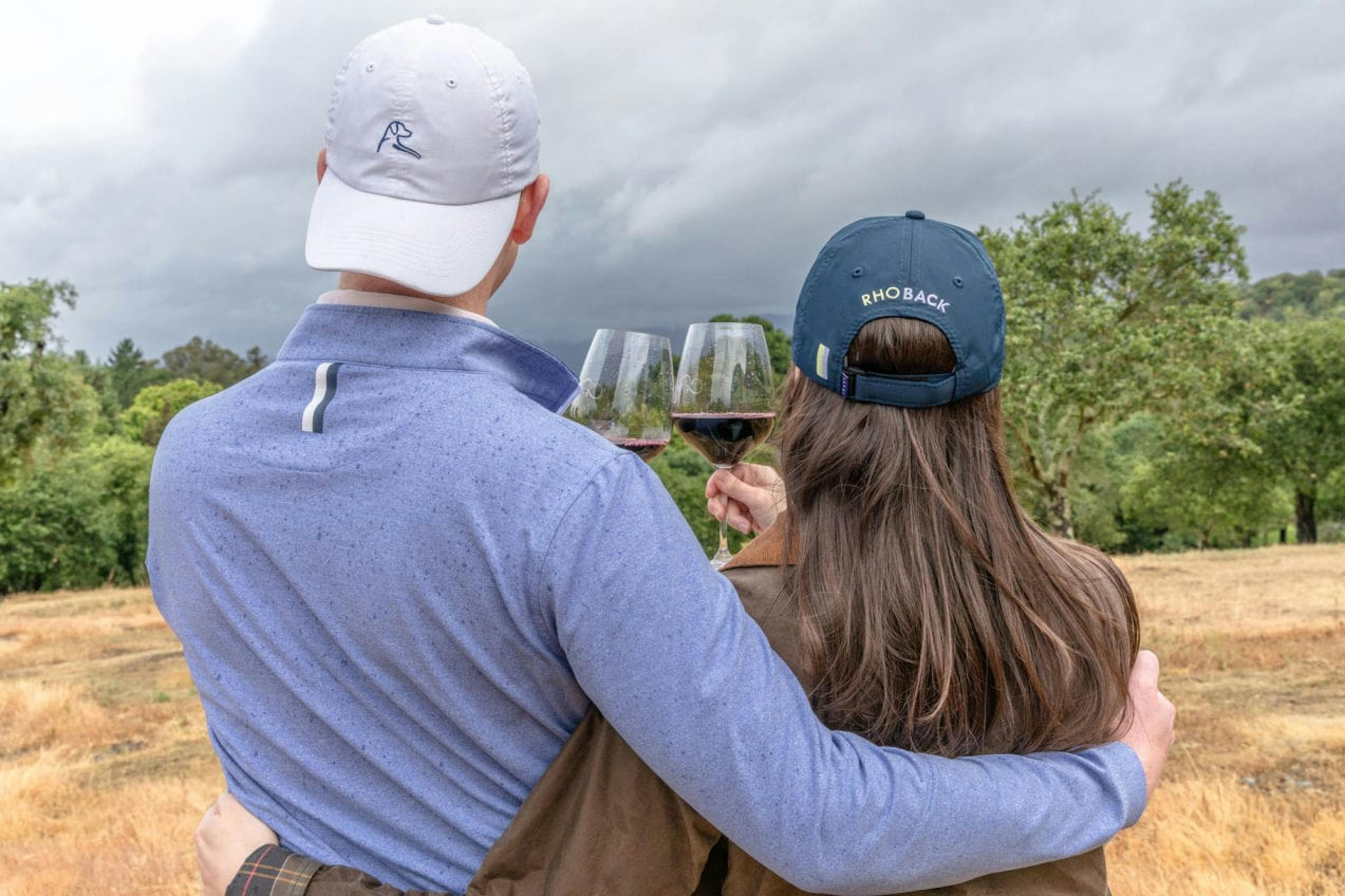 Couple drinks Two Old Dogs winery wine wearing Rhoback apparel