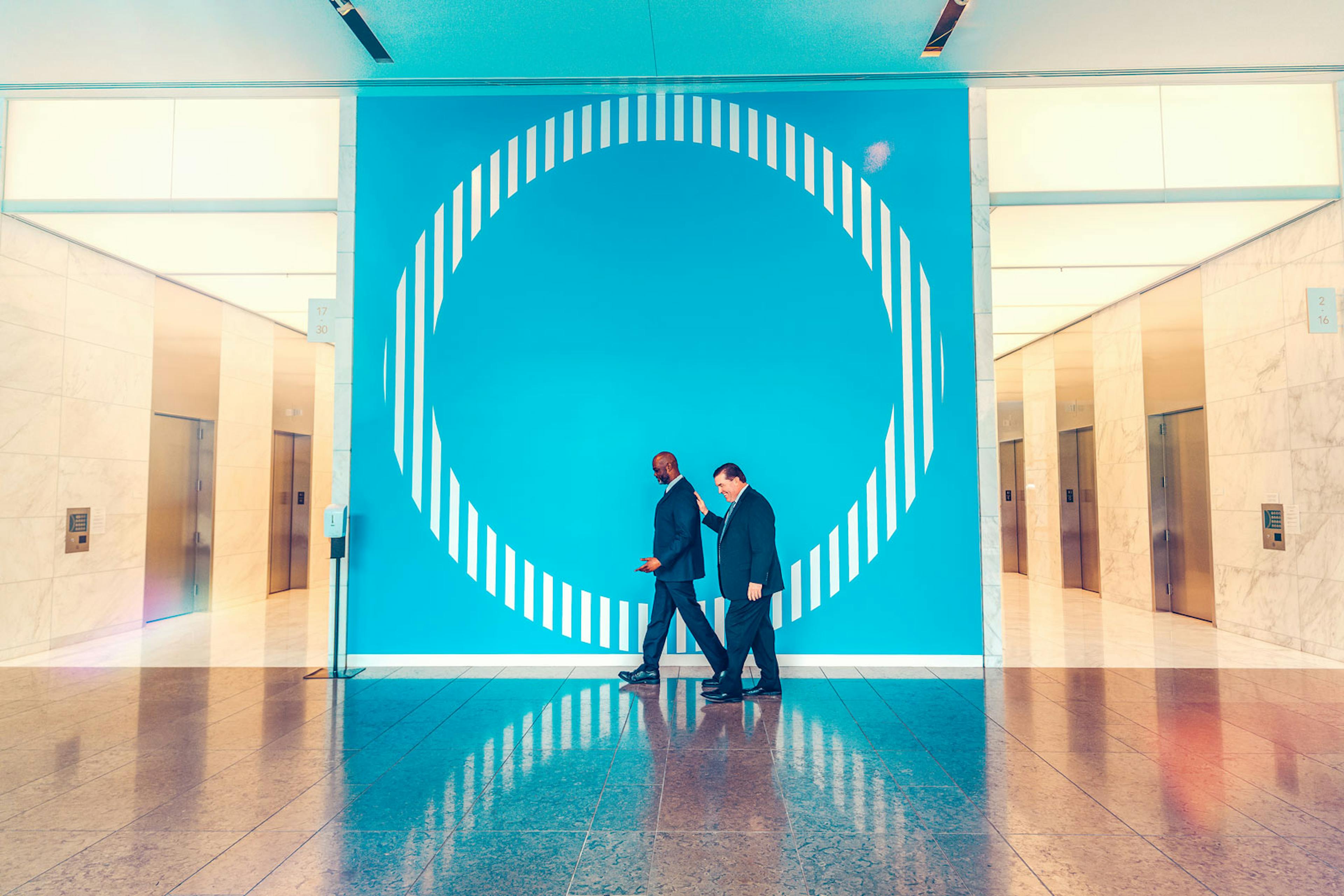 Santander Tower Security walking In front of logo wall