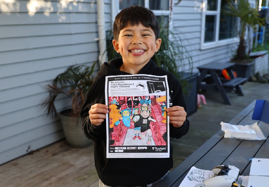 Photo of colouring in competition winner Logan aged 6 with his artwork