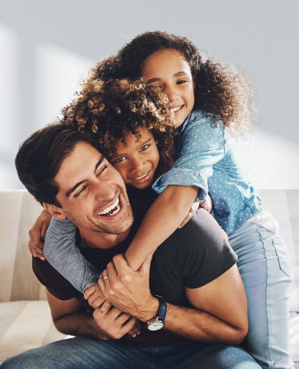 Filhos na costa do pai ambos abraçando ele.