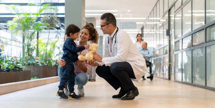 médico conversando com mãe e criança