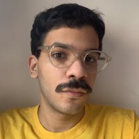Homem de óculos e camiseta amarela.