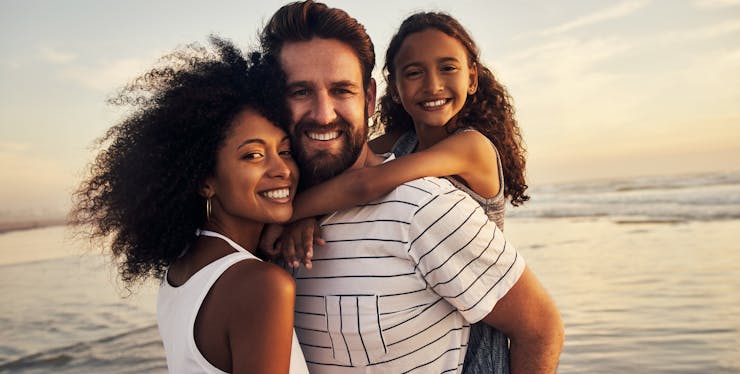 família sorrindo na praia