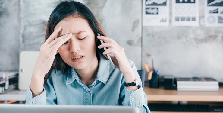 Mulher falando no celular e com expressão preocupada