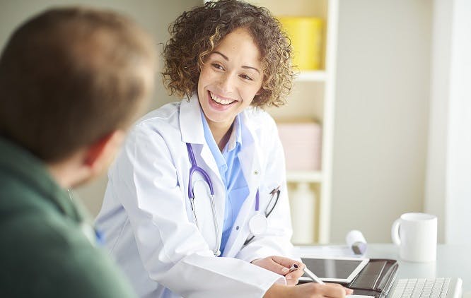 Médica sorrindo para um paciente