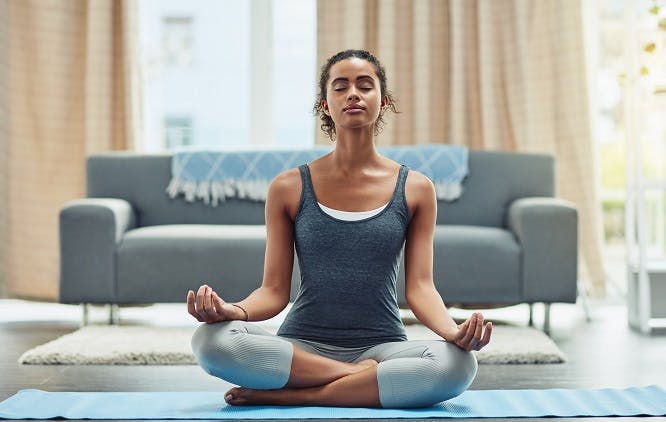 mulher meditando na sala de casa