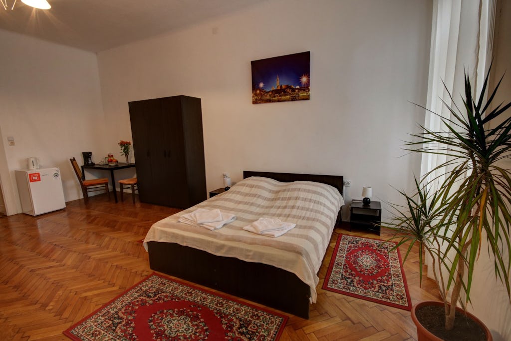 Large bed with fresh towels in front of window