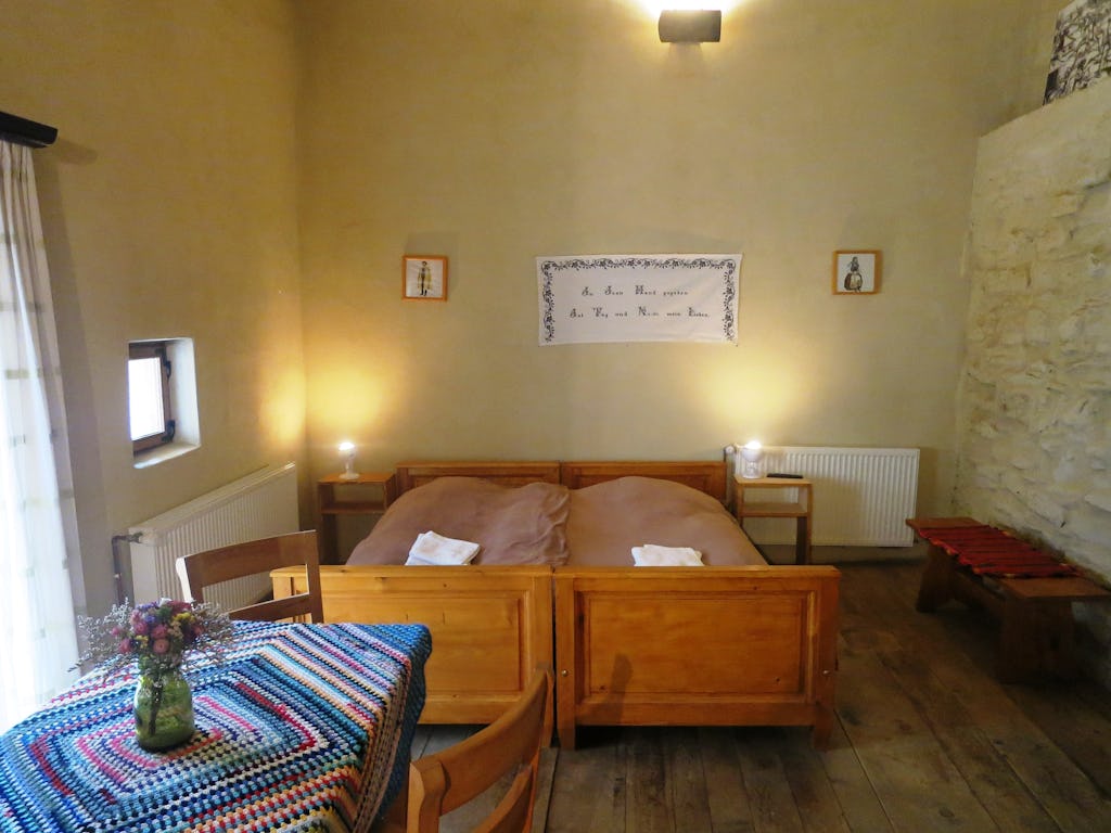 Table with flowers, two beds and the medieval walls 