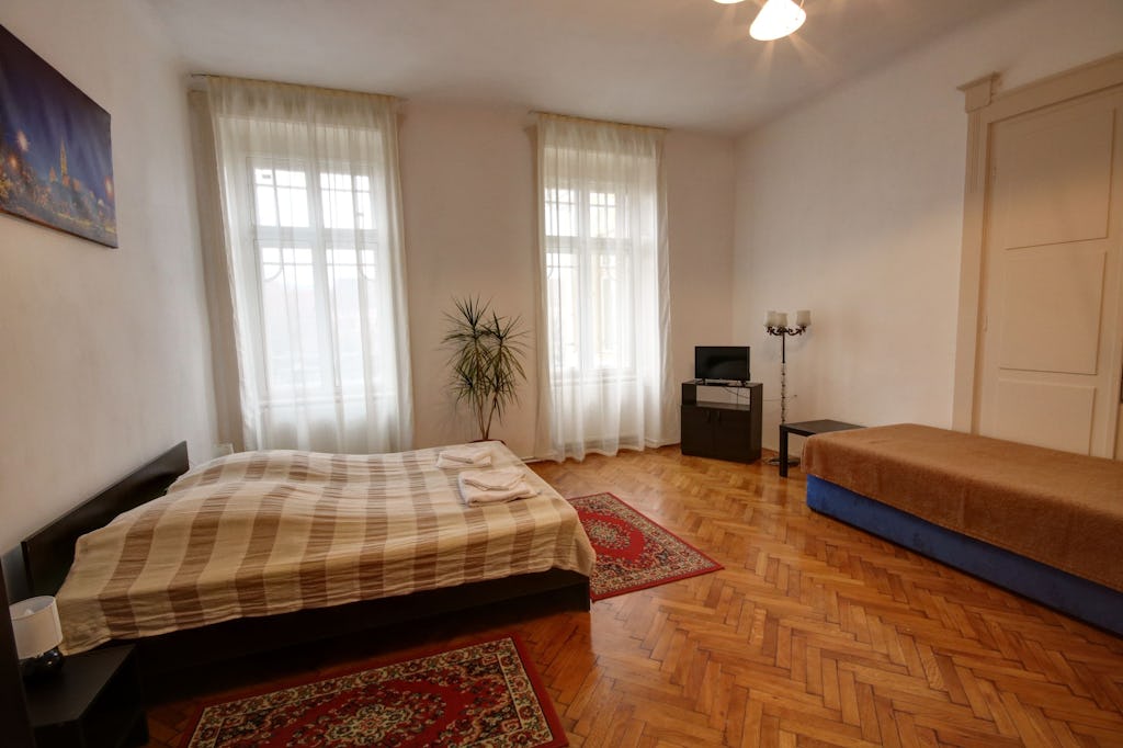 Two-person bed and a single bed with tv in room