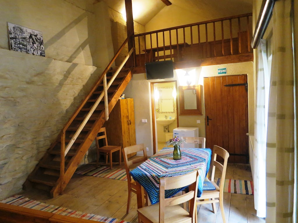 Treppen zum oberen Zimmerteil mit Tisch und Schrank