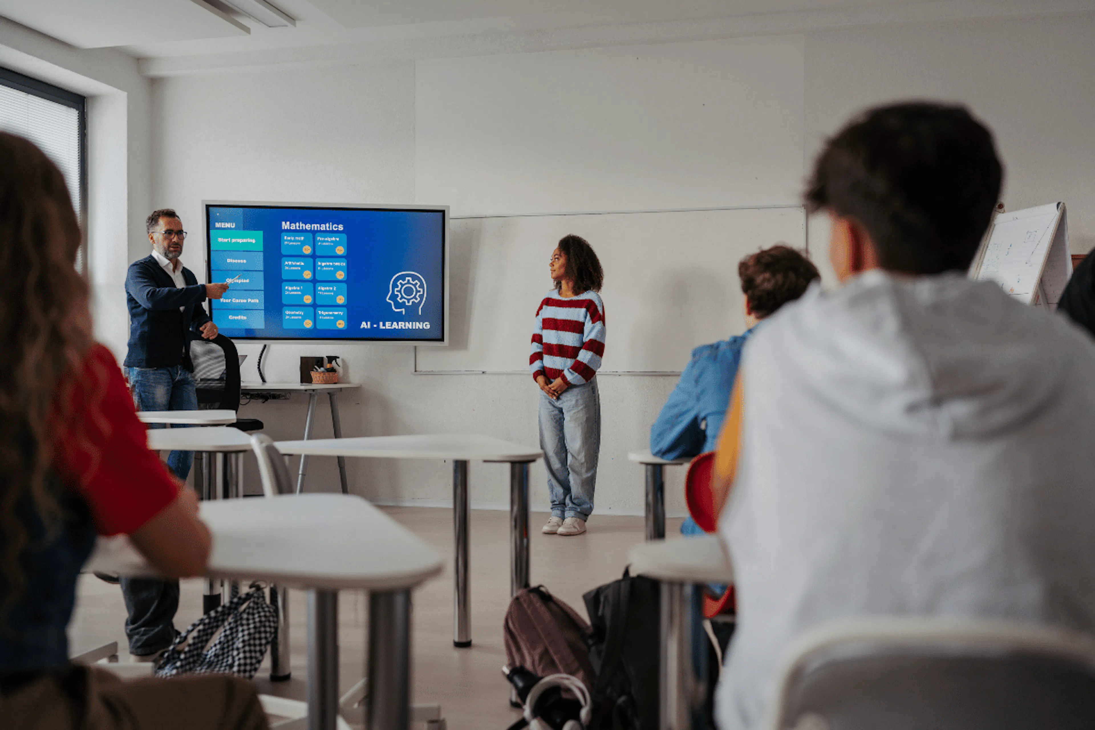 High school students in a classroom looking at a large screen 