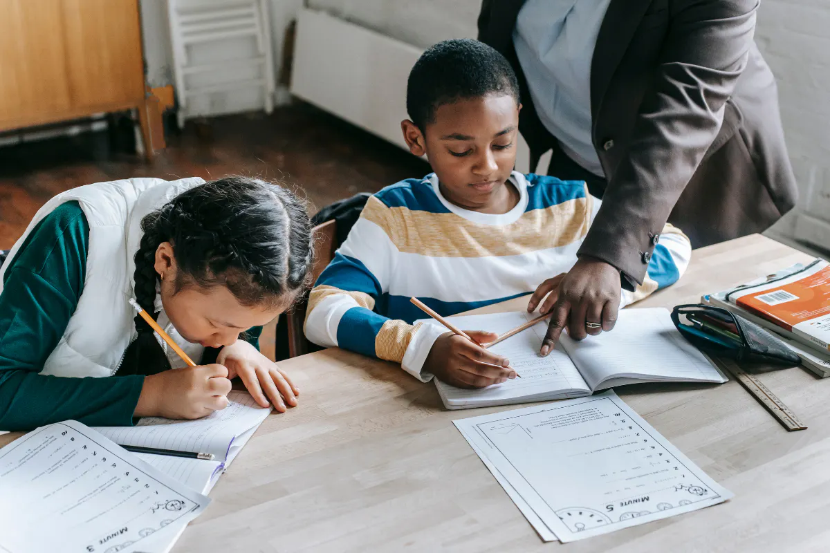 A tutor teaching 2 young students