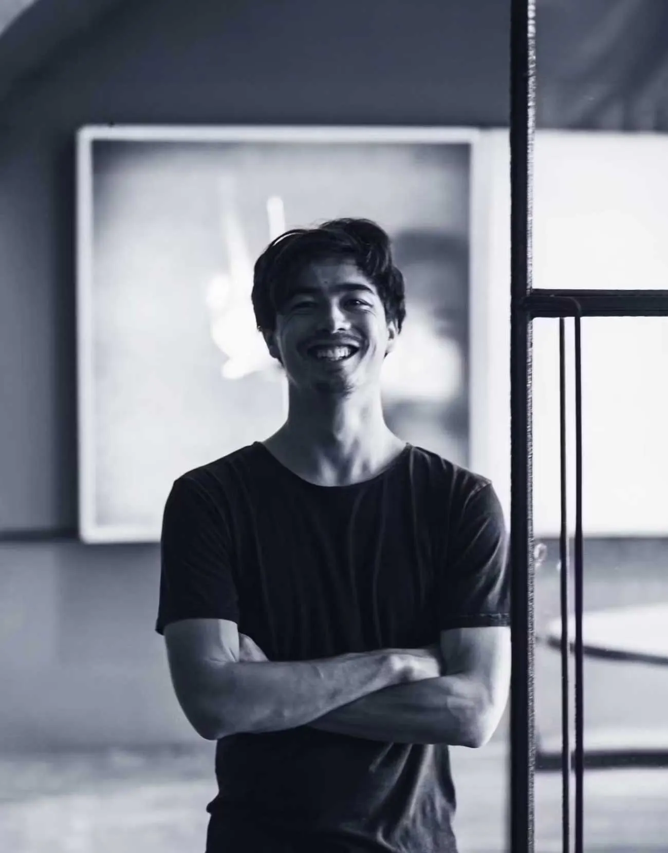 Owen, Co-founder of Two Moons Studio, smiling with arms crossed