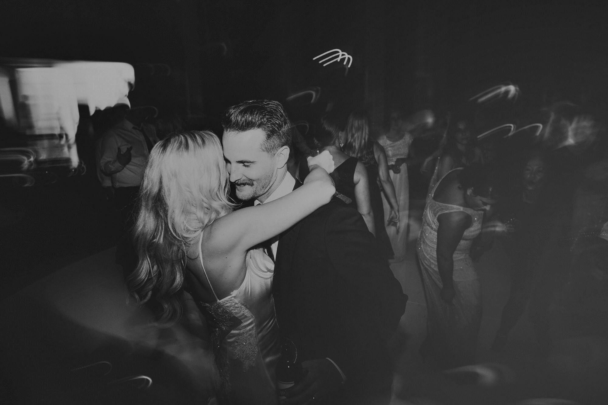 moody black and white couple dancing on wedding night