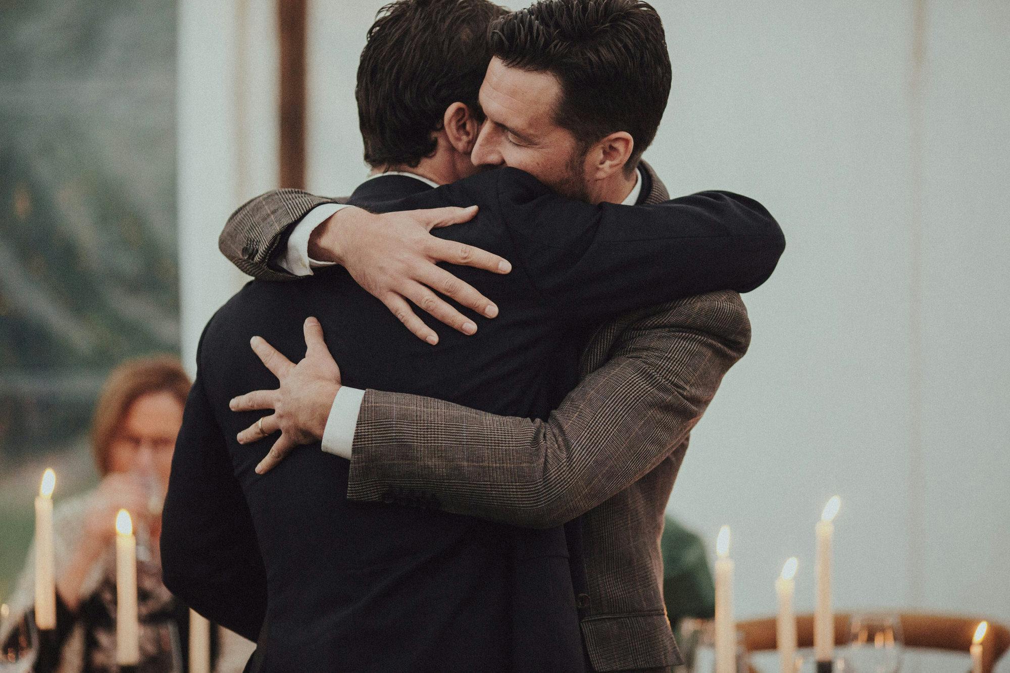 candid photos of hugs between groom and best man