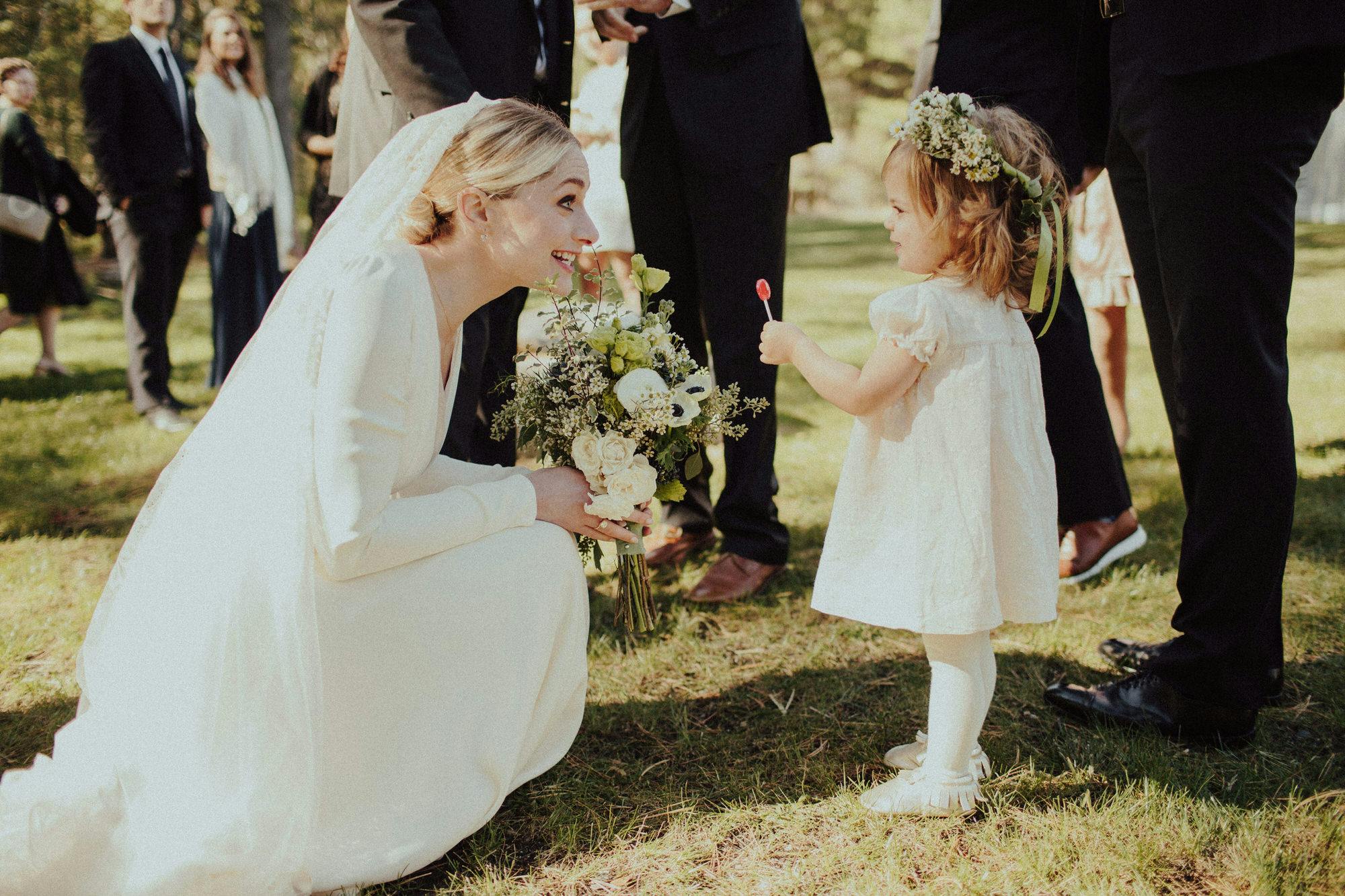 candid wedding shot of bride and flower girl