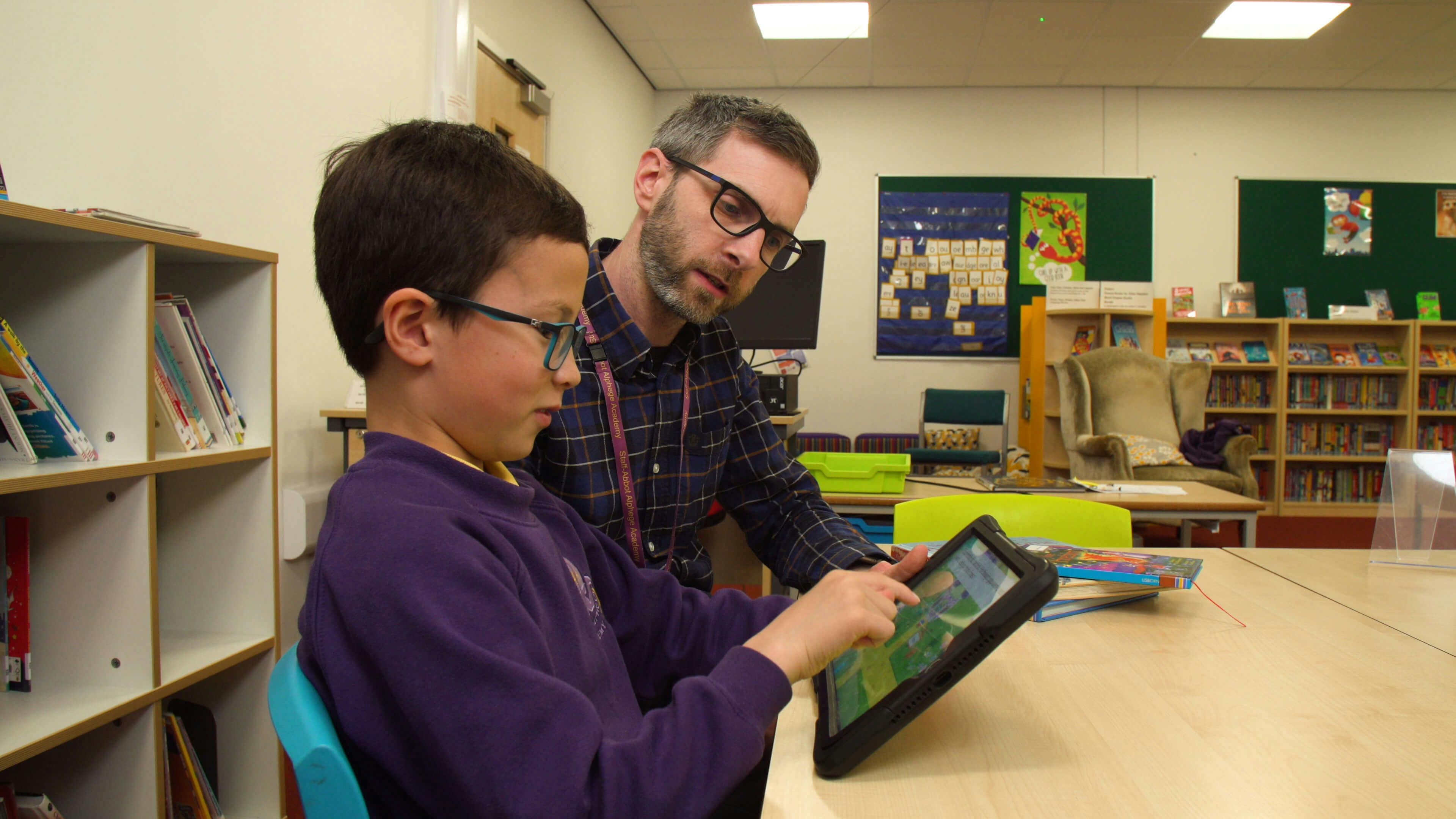 Teacher Adam reading with a student