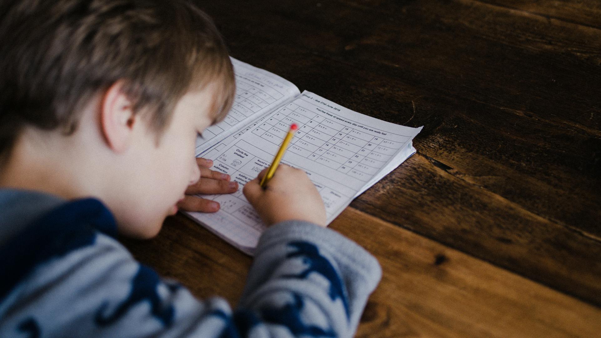 A young boy works on a maths exam paper.