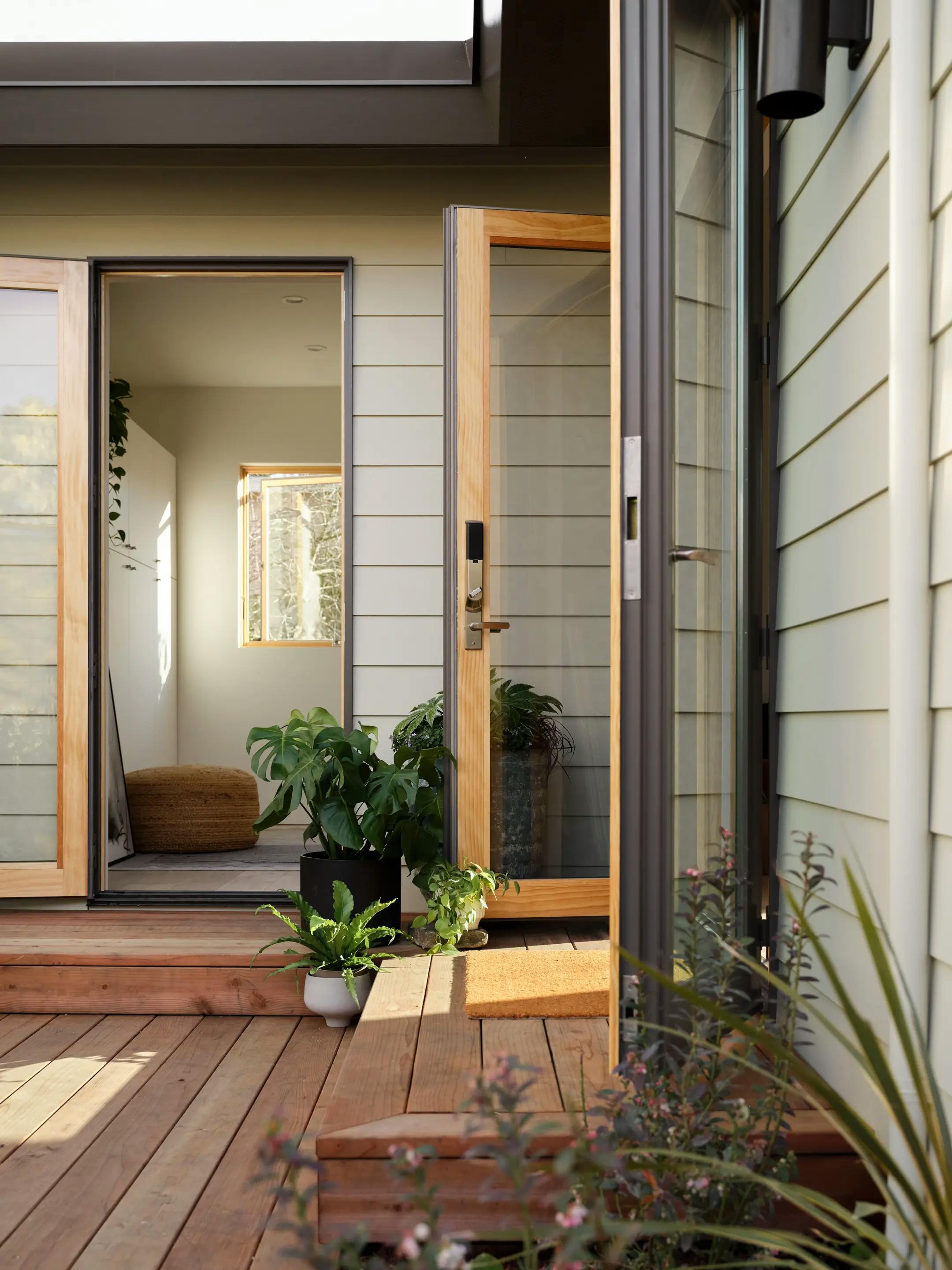 Exterior detail shot of a Type Five ADU showing open French doors with golden hour light and shadows