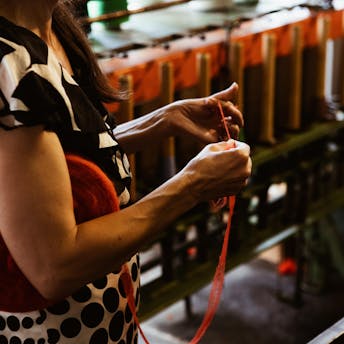 Julia, guide du musée textile, nous montre un fil de laine