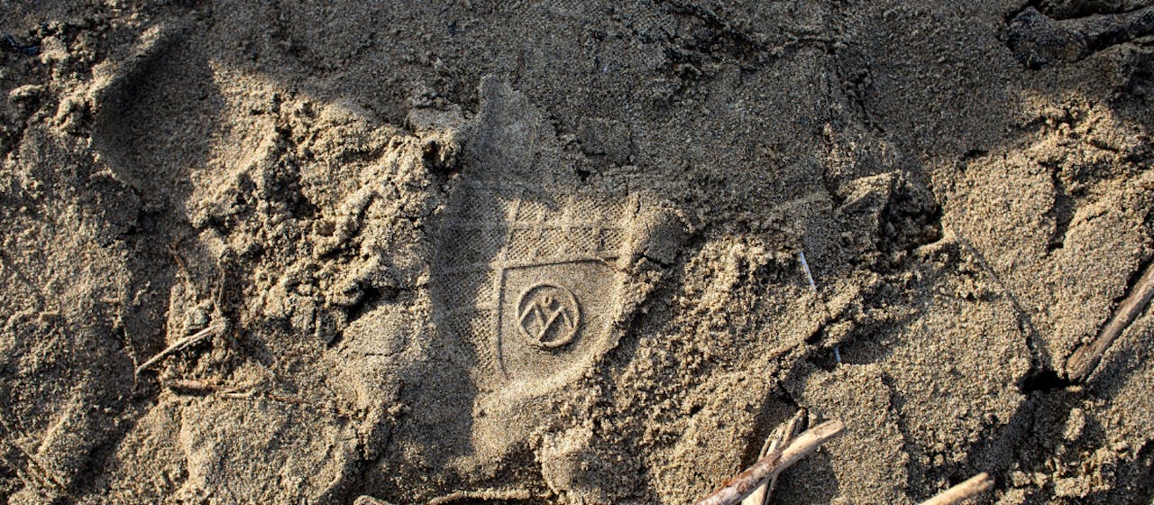 Empreinte d'une basket Ubac dans le sable