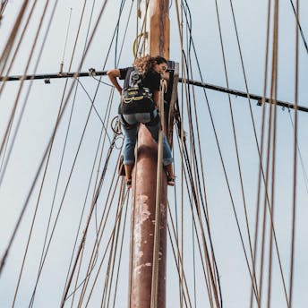 Marin grimpant le mât du voilier