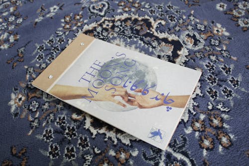 A newprint book with a moon and hands reaching for each other called The Moon's Song.