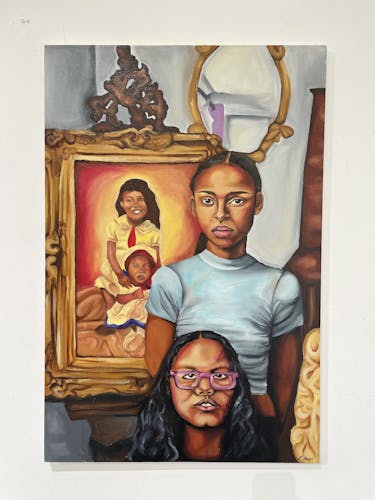 A painting of two young girls, one standing gazing directly at the viewer, and the other kneeling at the bottom of the image with the image cutting off at her neck. Behind the two girls is a portrait of two young girls holding one another in a similar way, held in a large frame. The room is condensed, with multiple ornamentary items, such as a mirror, a frame to hold the portrait, and a blanket in the bottom right corner of the image. The juxtaposition of the two girls in the room and the two girls in the portrait demonstrate a reference to multiple generations and familial bonds. 