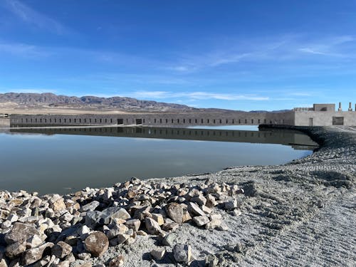 Rendering of a linear building that gradually slopes down into a flooded polygon of Owens Lake.