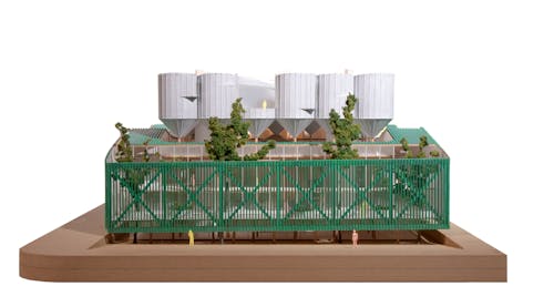 Physical model of a building featuring a garden balcony below a series of cylindrical towers.